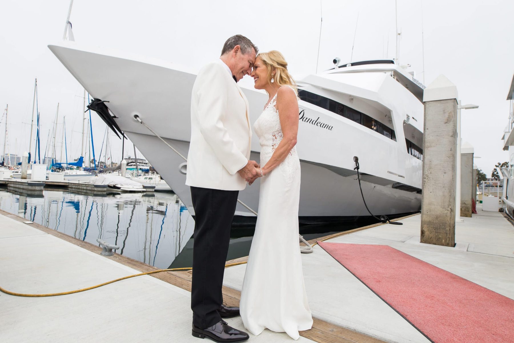 Married couple stand before the Dandeana yacht