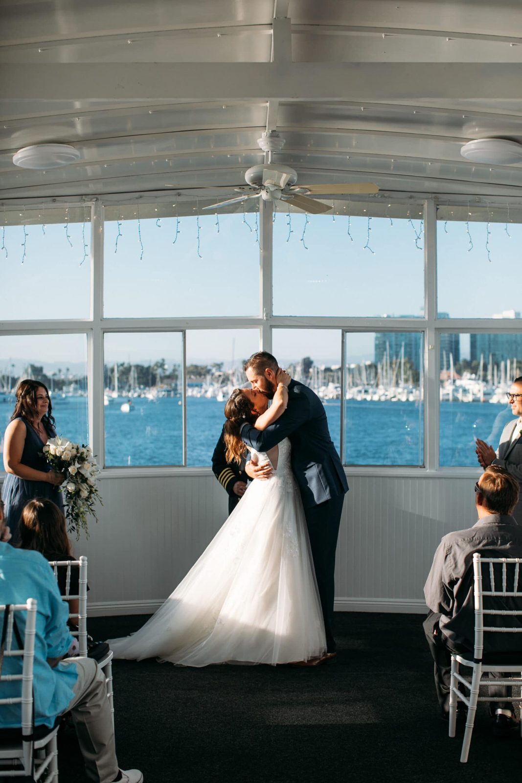 Bride and groom kiss during their wedding ceremony aboard a FantaSea yacht in Marina del Rey